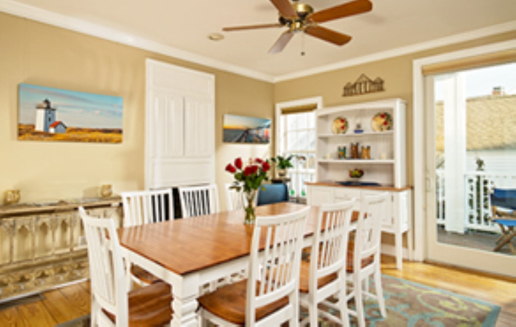 dining room with beige walls, white trim, mahogany/white dining table and chairs - open slider to the outside deck
