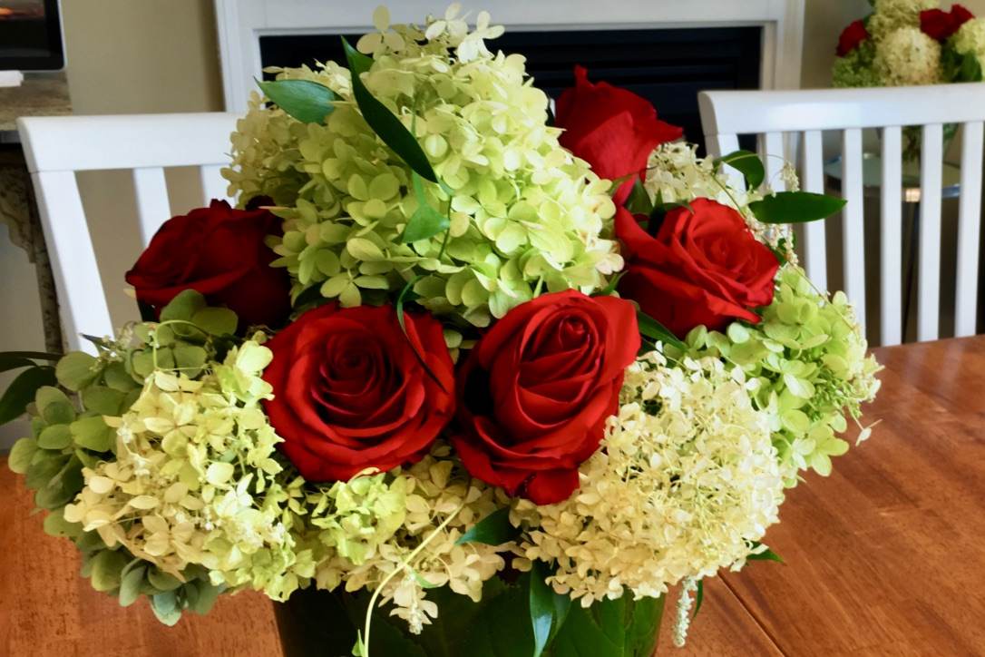 tastetfully arranged bouquet of flowers: white hydrangeas and red roses